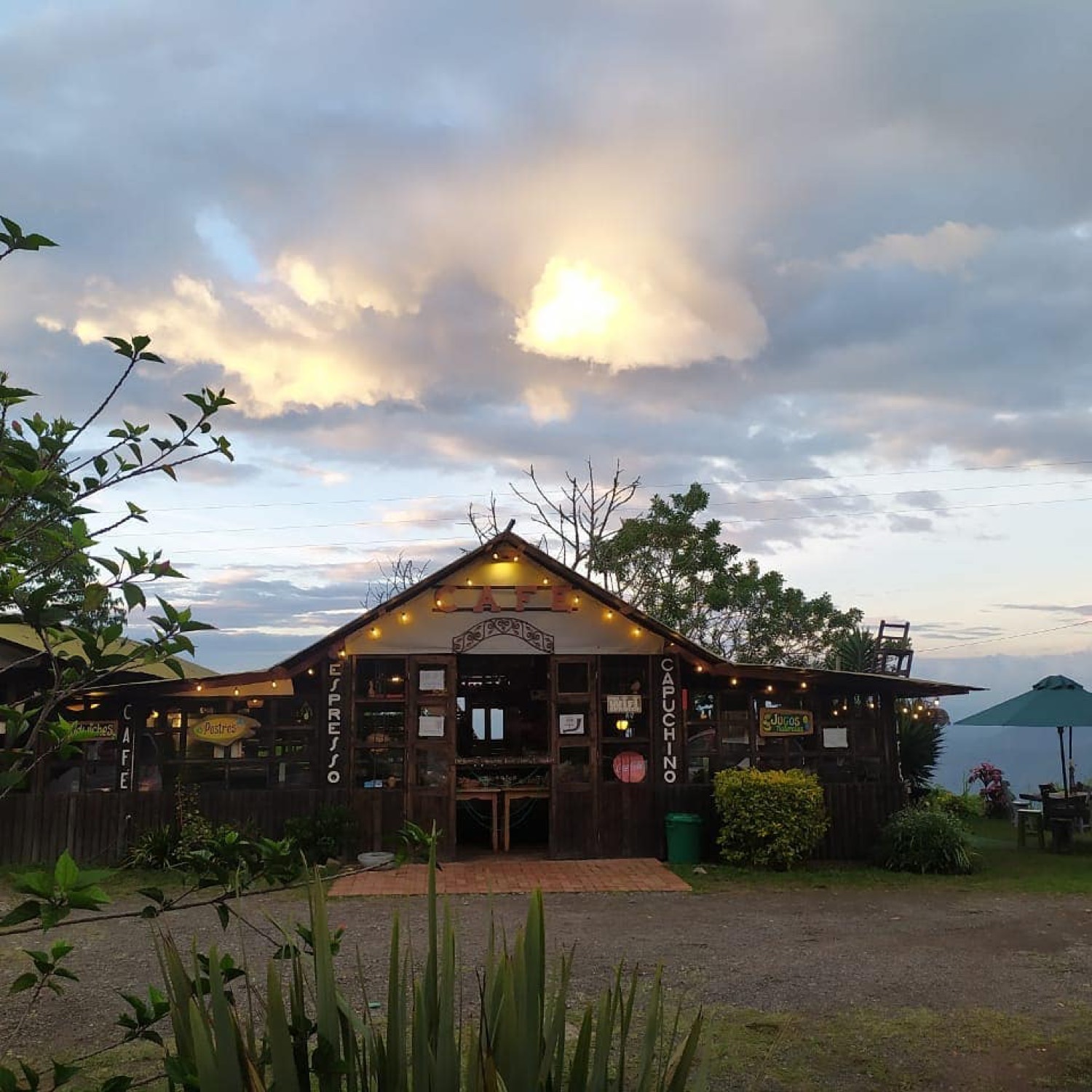 Fachada de madera de Café Mucha Vista al atardecer